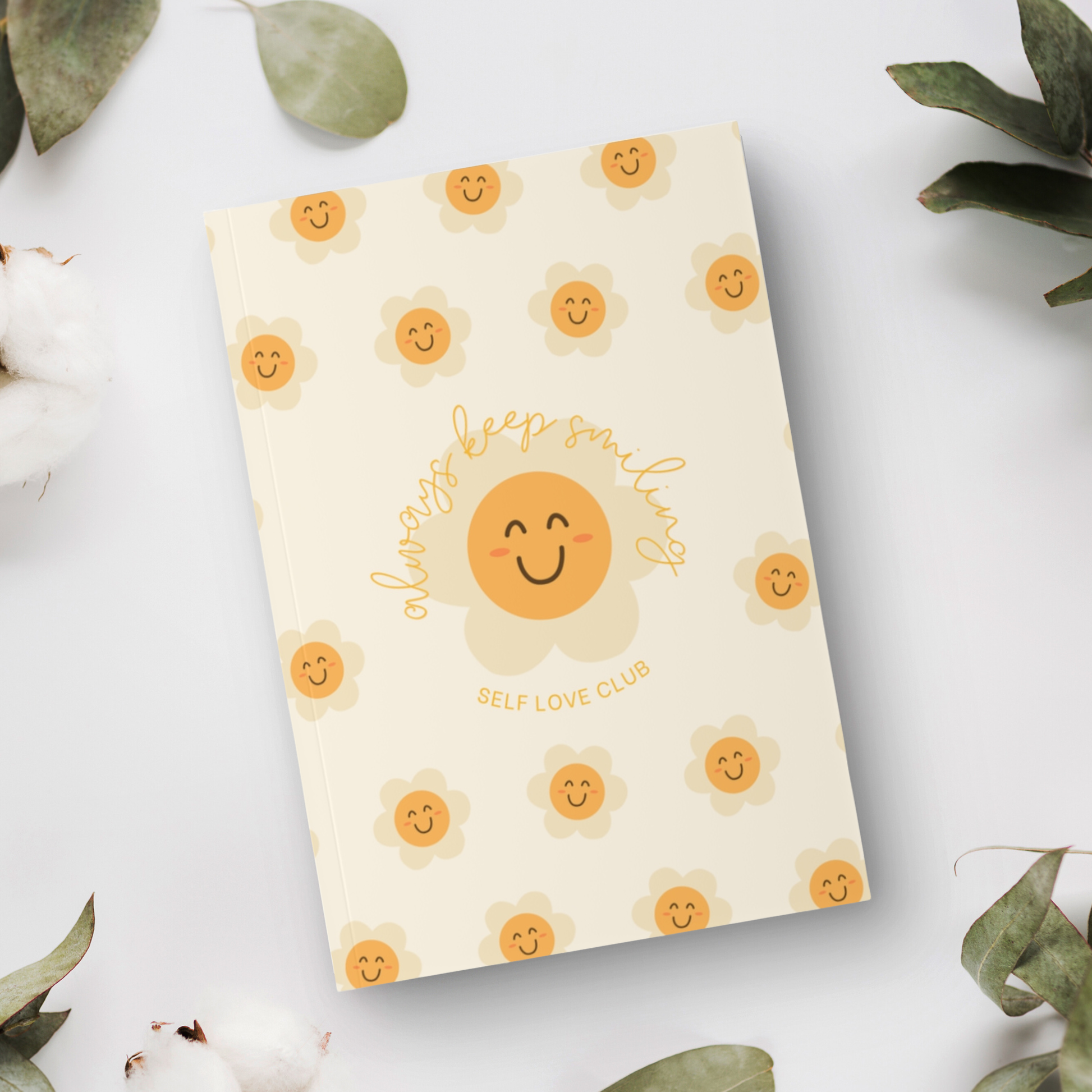 Notebook with flower and smiling face design on a light background