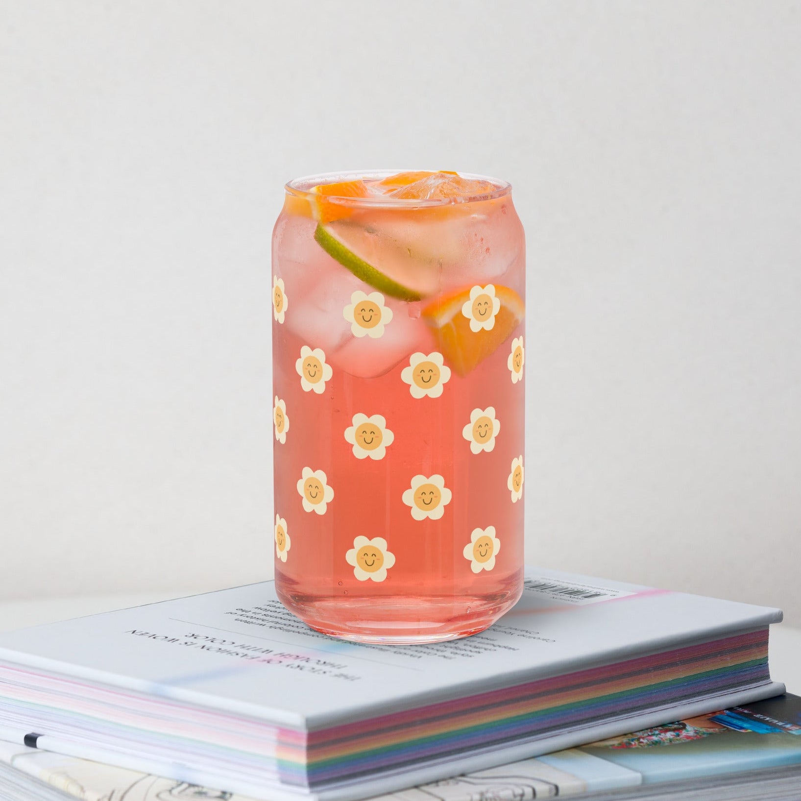 Floral-patterned glass with a drink on top of books