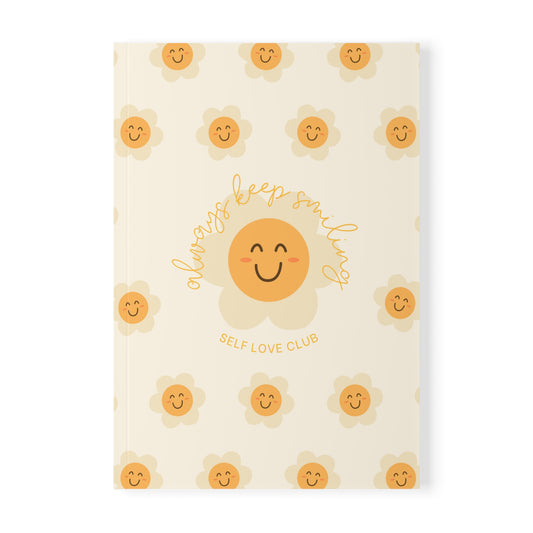 Notebook with flower and smiling face design on a white background