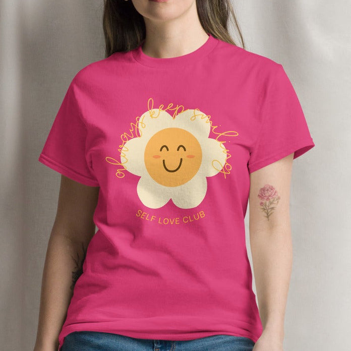 woman wearing a pink tshirt with a happy flower graphic