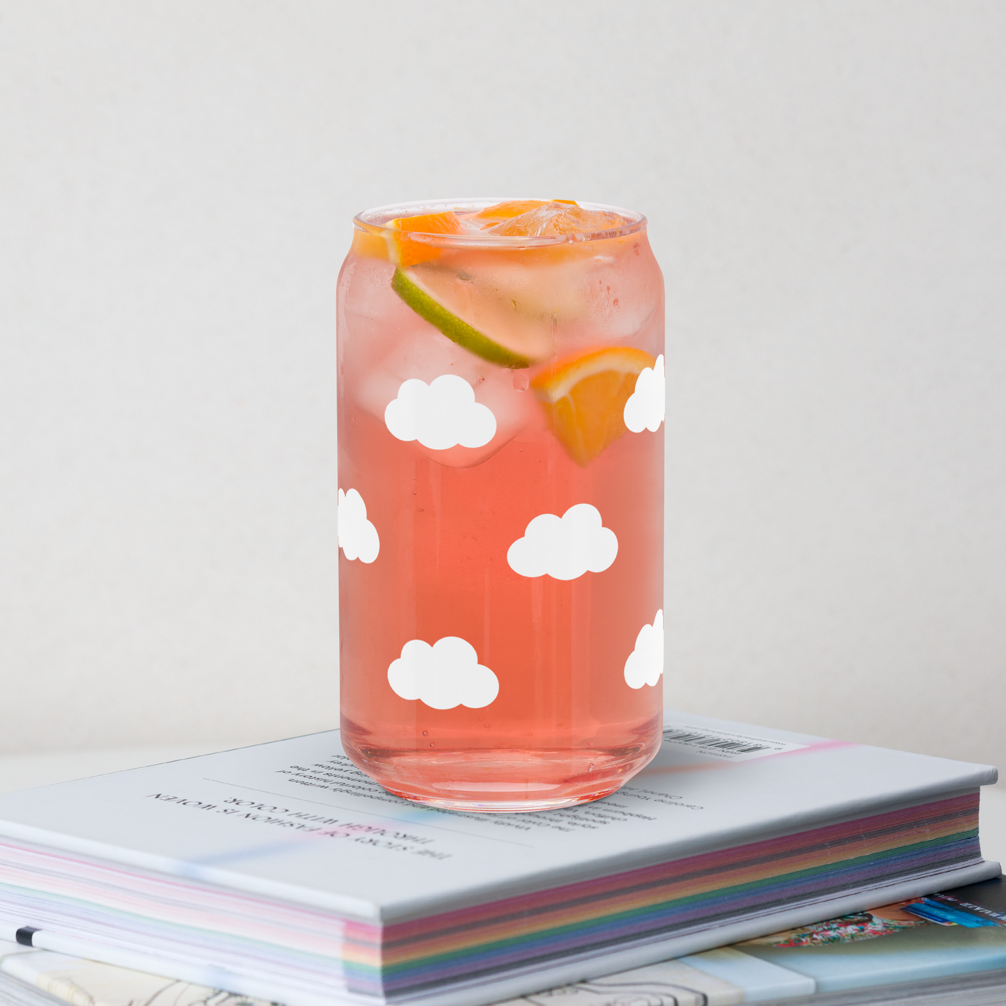 Glass with pink drink and cloud pattern on a stack of books 
