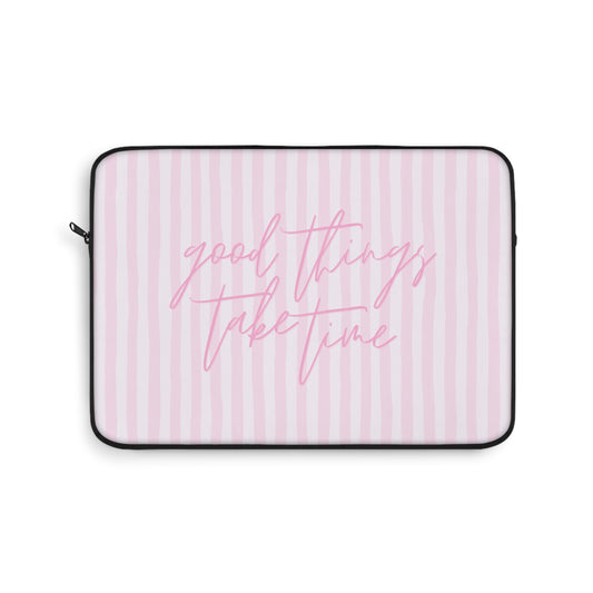 Laptop sleeve with pink text 'good things take time' on a striped background