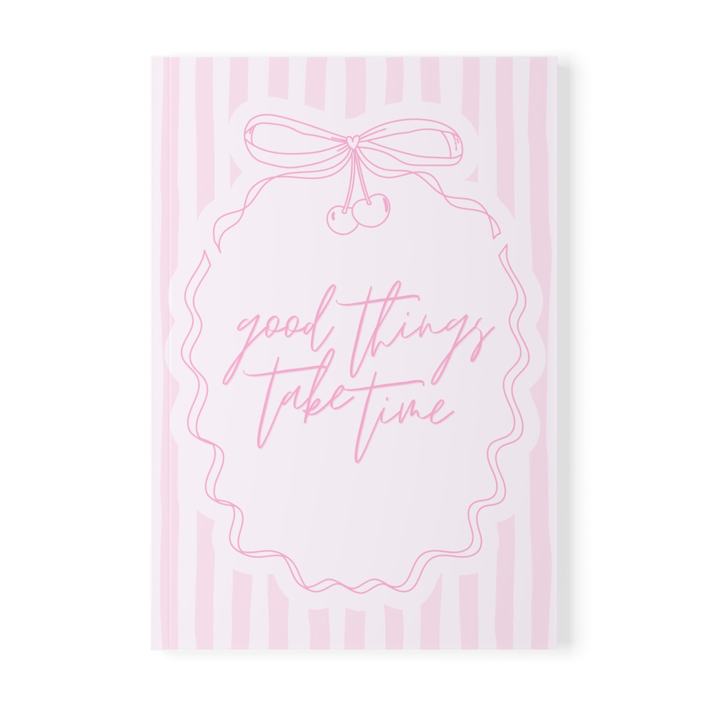 Notebook with 'good things take time' text and a bow design on pink striped background