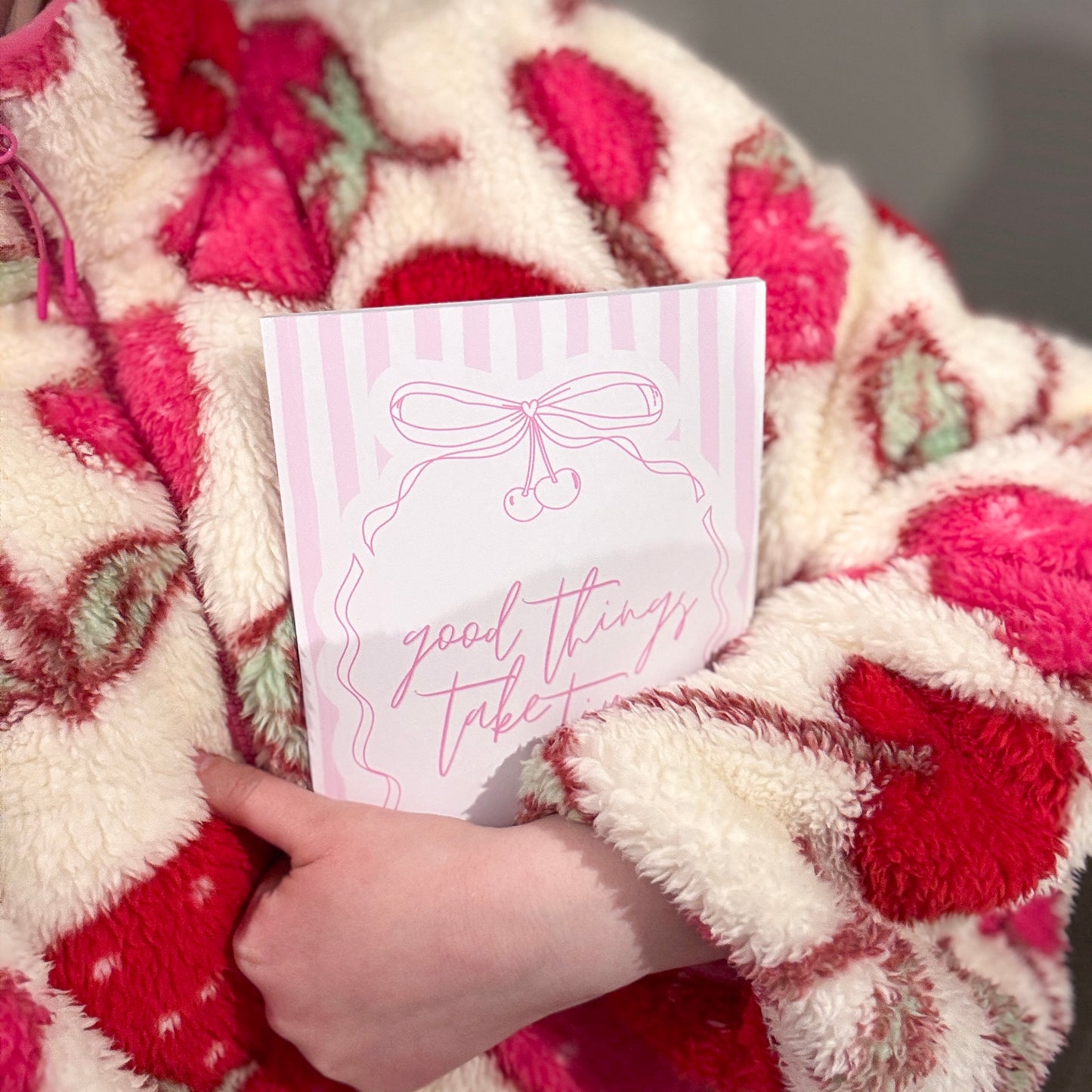 Person holding a notebook with 'good things take time' text.
