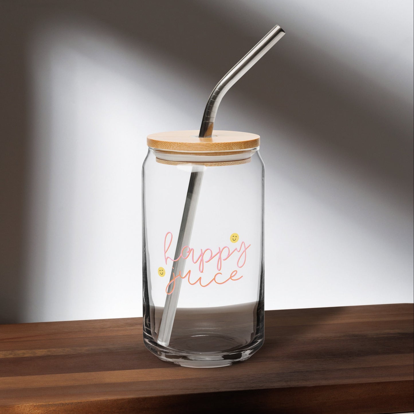 Happy juice glass jar with wooden lid and metal straw on a wooden surface
