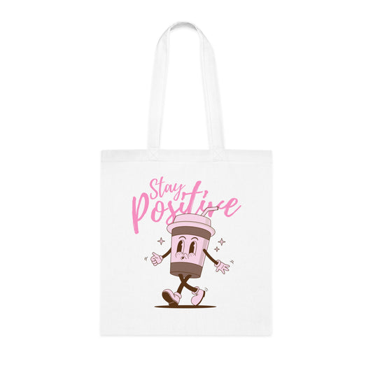 White tote bag with a cartoon character and 'Stay Positive' text on a white background