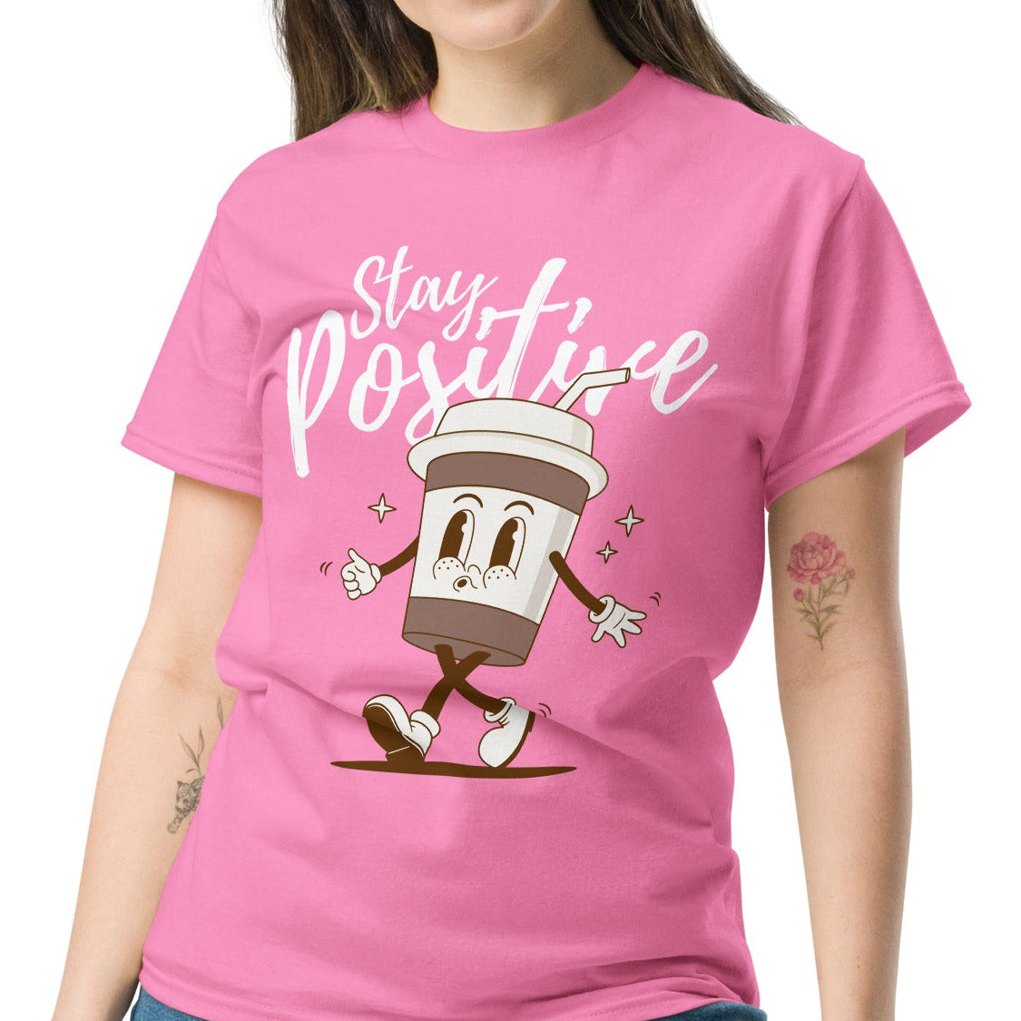 woman wearing a pink tshirt with a coffee character and the quote stay positive