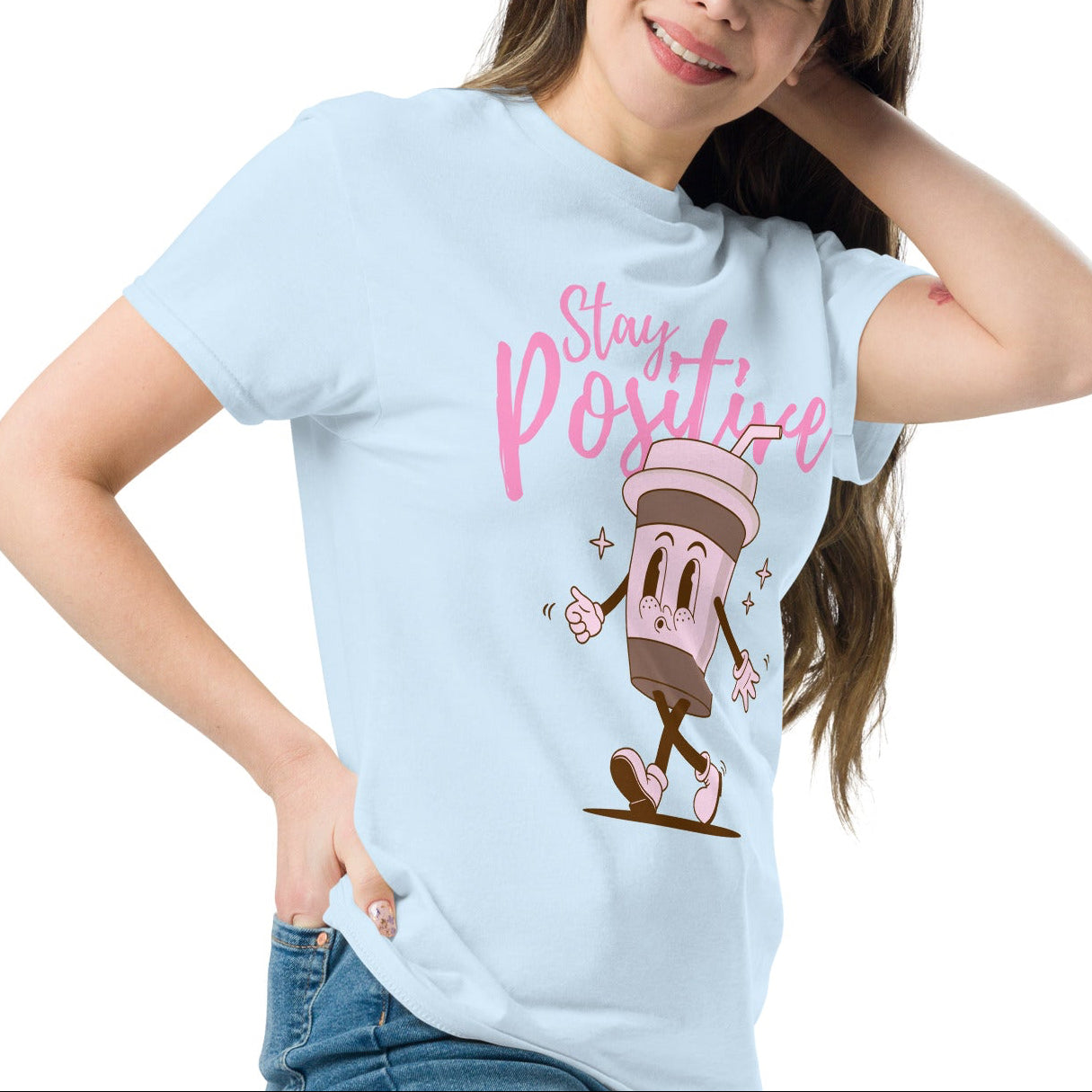 woman wearing a light blue tshirt with a coffee character and the quote stay positive